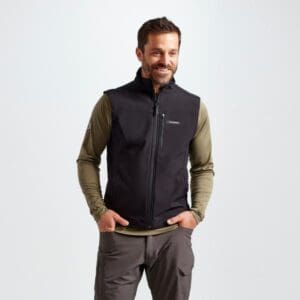 A man standing in front of the camera wearing a black vest.