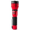 A red and black flashlight is on the ground.