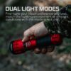 A red and black flashlight is on the ground