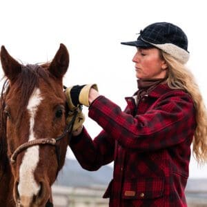 A woman is brushing the horse 's hair