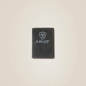 A black and silver ariat patch on a white wall.
