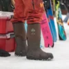 A person wearing snow boots and skis in the background.